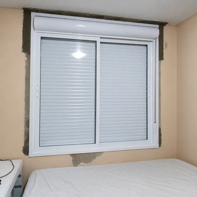 Janela de alumínio branco com persiana fechada em um quarto