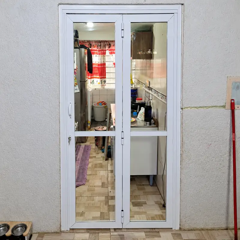 Porta de alumínio branco de duas folhas com vidro na passagem para a cozinha